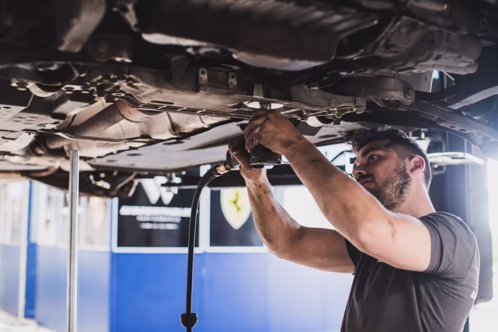 KFZ Meister Kai Wagenthaler montiert Auto in KFZ Werkstatt fotografiert von Florian Breitenberger