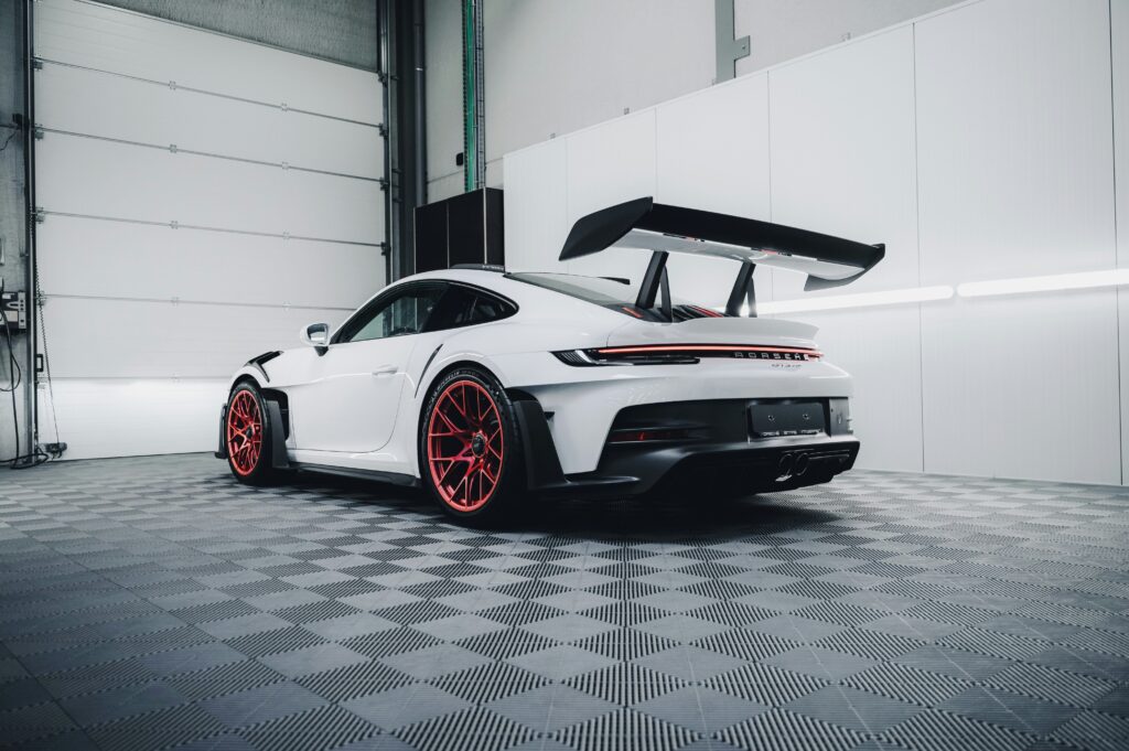 Weißer Porsche in Werkstatt von leicht unten fotografiert – Wagenthaler Performance