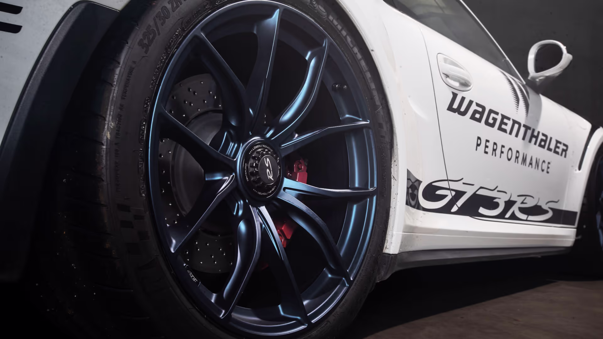 Weisser porsche in werkstatt von leicht unten fotografiert